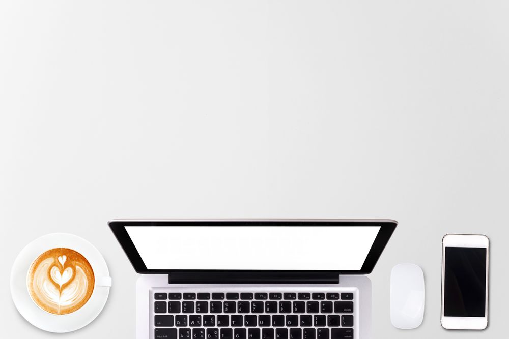 Top view laptop computer or notebook, mobile phone and cup of latte art coffee on wooden table