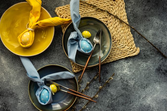 Top view of Easter holiday table setting with decorative blue and yellow eggs