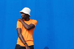 Black man in bright sporty outfit and cap