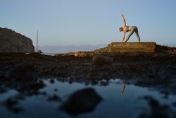 Female doing stretching exercise on seashore