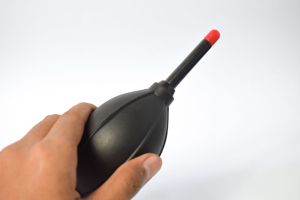 Hand holding blower for lenses