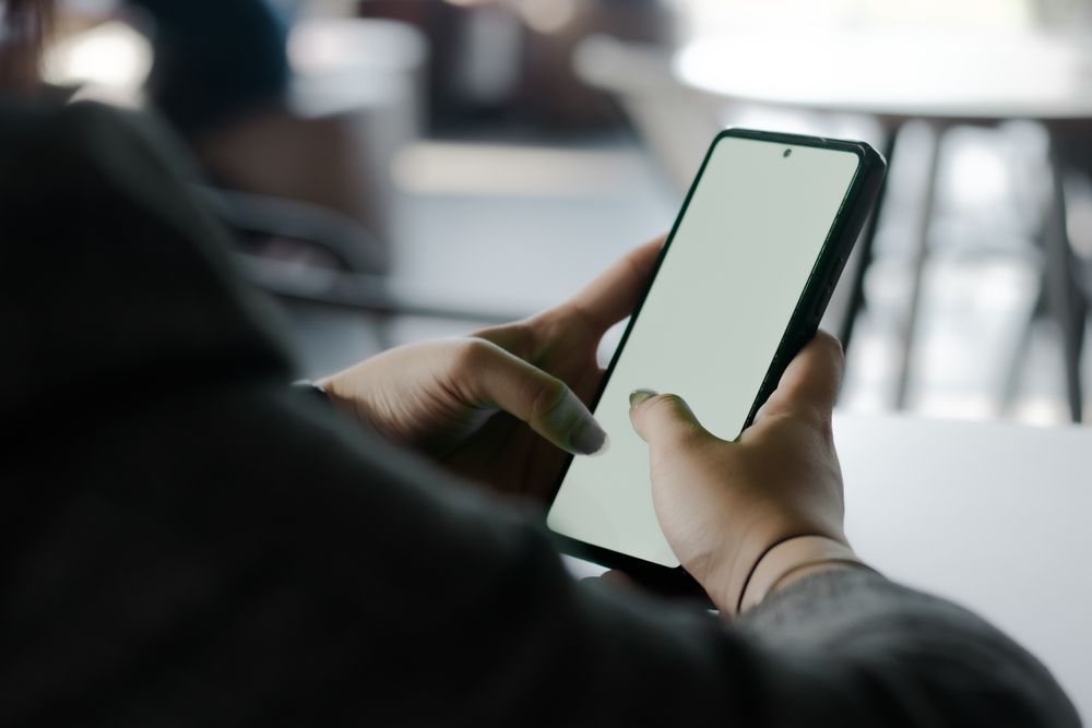 Digital interaction: Hands holding smartphone with blank display
