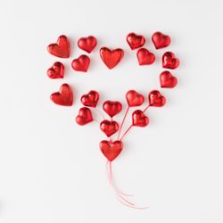 Heart made of red foil hearts on light background