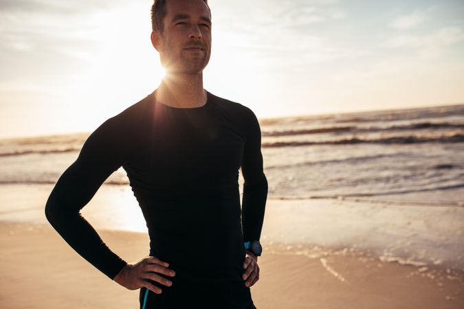 Portrait of confident male athlete standing on the beach