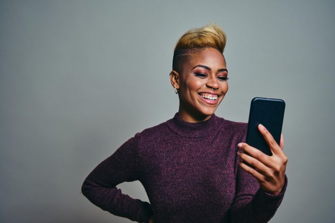 Black woman laughing at a text on a cell phone