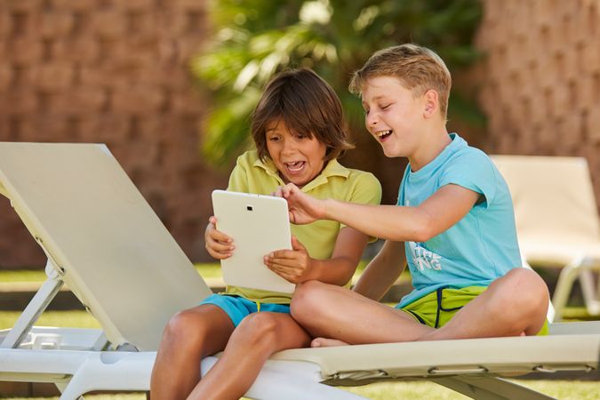 Boys using tablet in garden