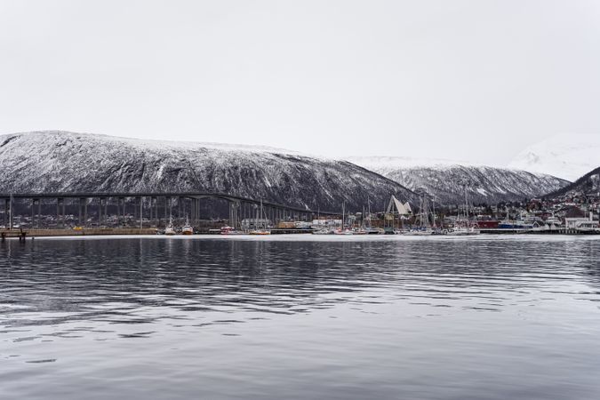 Landscape of sea bay next to big snowy cliff