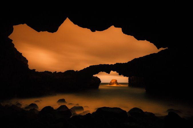 Amazing cave near water and blue sky
