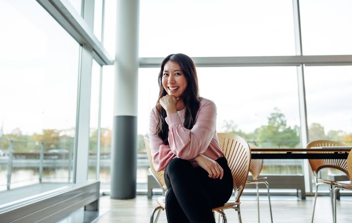 Portrait of attractive young businesswoman sitting on chair in office
