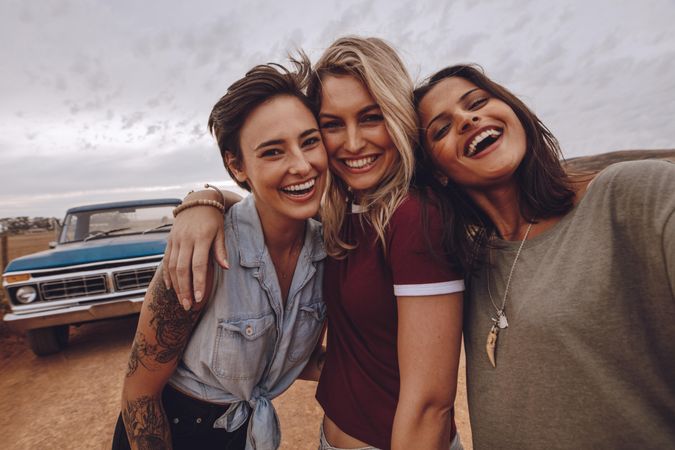 Three young women taking self portrait on road trip