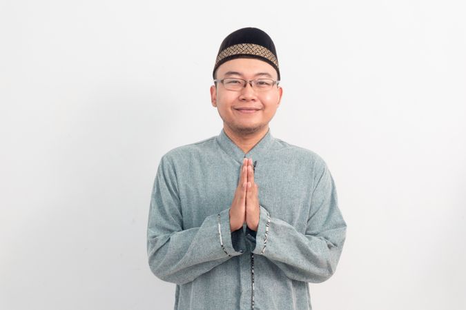 Asian Muslim man smiling doing greeting pose during Ramadan