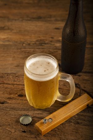 Glass full of cold beer on the wooden table