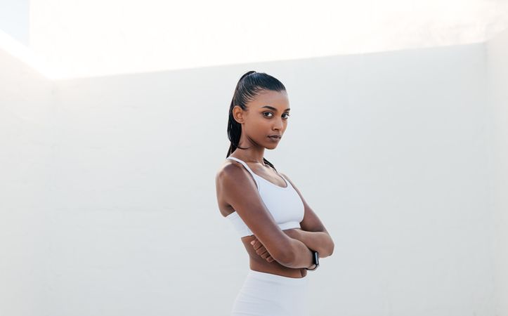 Fit woman standing with arms crossed in workout gear