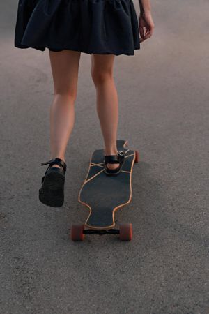 Woman in skirt skating on board
