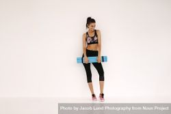 Sportswoman with yoga mat in fitness studio 4mWMo7