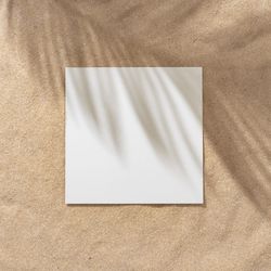 Sand with palm leaf shadows and central square
