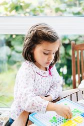 Girl playing with mosaic board game