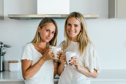 Women with coffee chatting in kitchen