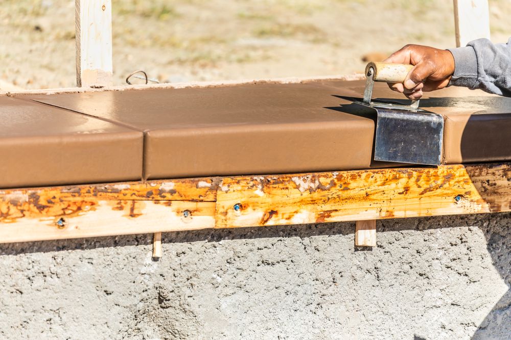 Construction Worker Using Stainless Steel Edger On Wet Cement Forming Coping Around New Pool
