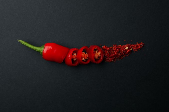 Chopped chilli pepper and spice on dark background