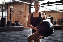 Woman working out with medicine ball in gym
