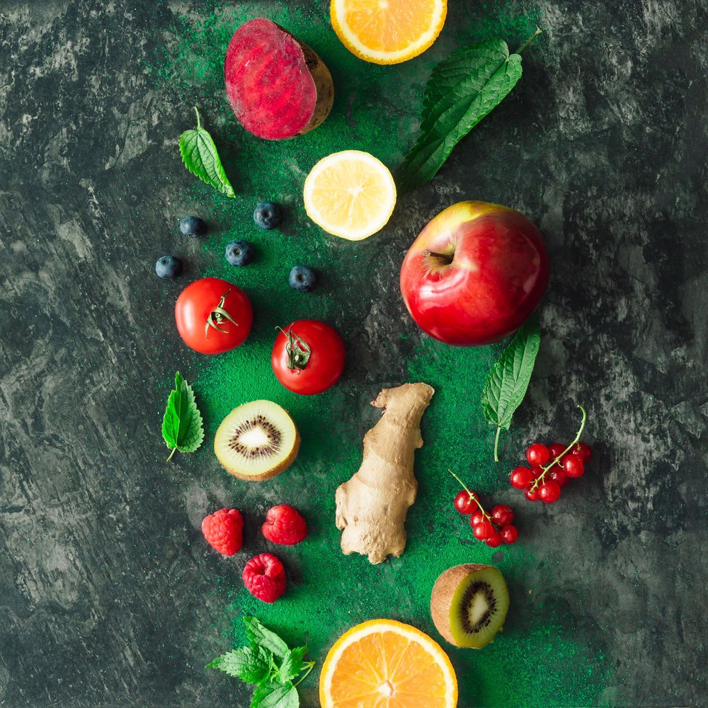 Fruits, vegetables and leaves on dark stone table background