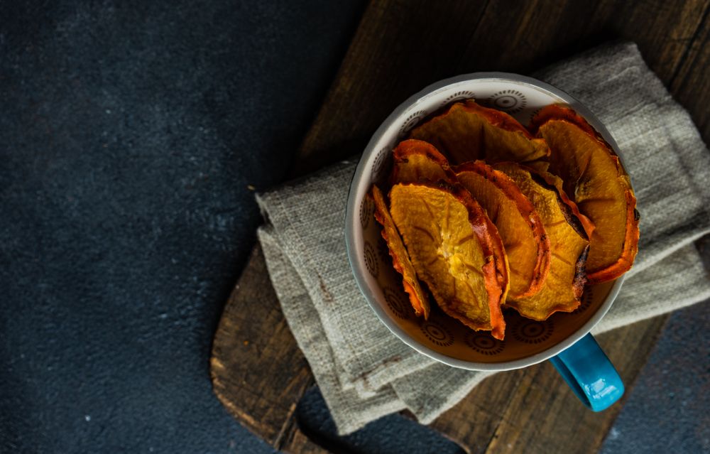 Top view of dried persimmon fruit slices in tea cup