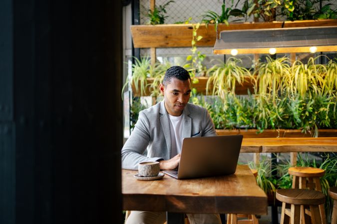 Man working on laptop at cafeteria