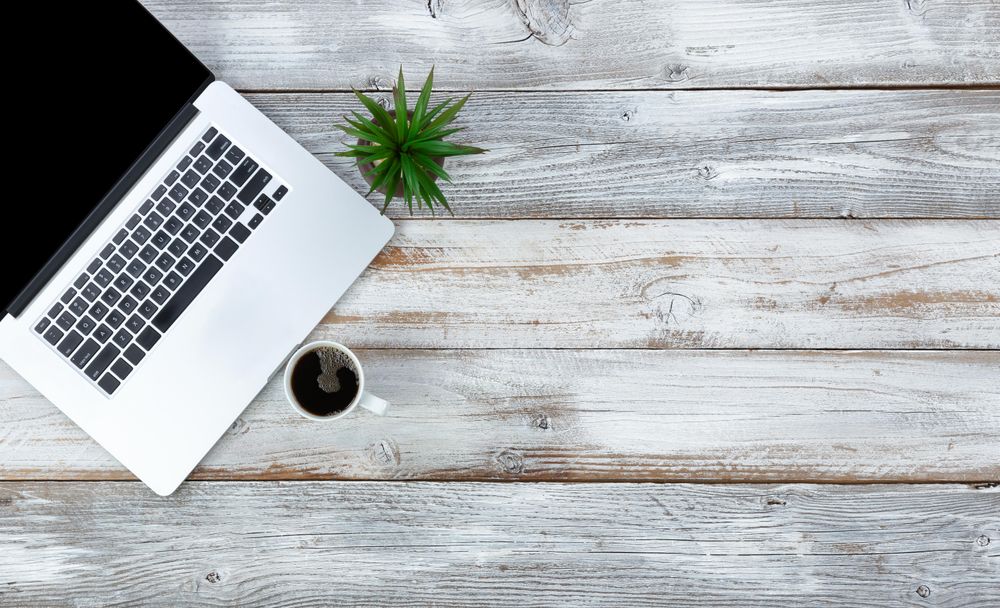 Work desktop with coffee and baby plant on wooden rustic wood