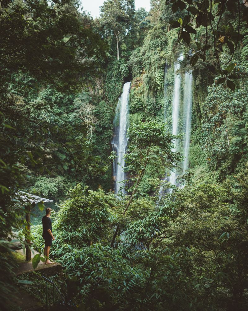 Tourist under hazy waterfall