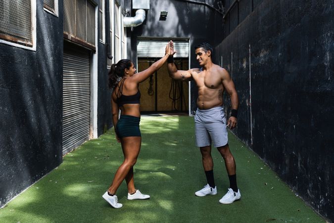 Sportive Hispanic couple giving high five