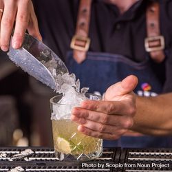 Bartender adding crushed ice to Caipirinha 5w6Z10