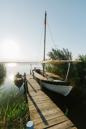 Moored boat by wooden pier