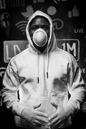 Grayscale photo of man in hoodie and facemask