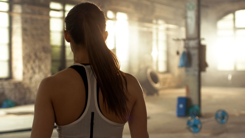Shot from the back of Athletic Woman Entering Gym. She's Confident