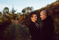 Smiling men hugging on countryside road