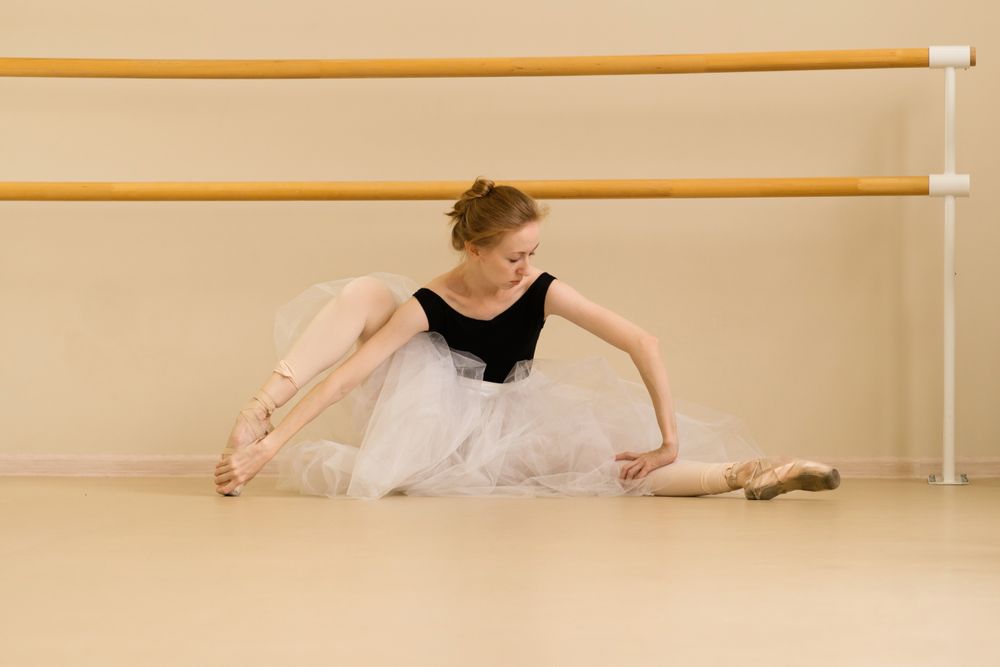 Ballet dancer stretches gracefully on the studio floor