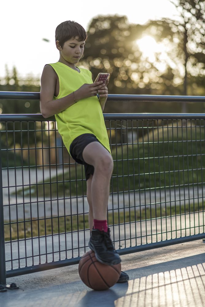 Young male using a phone outdoors at sunset
