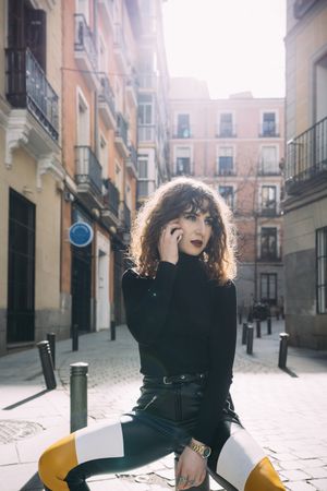 Young woman talking by phone in the street