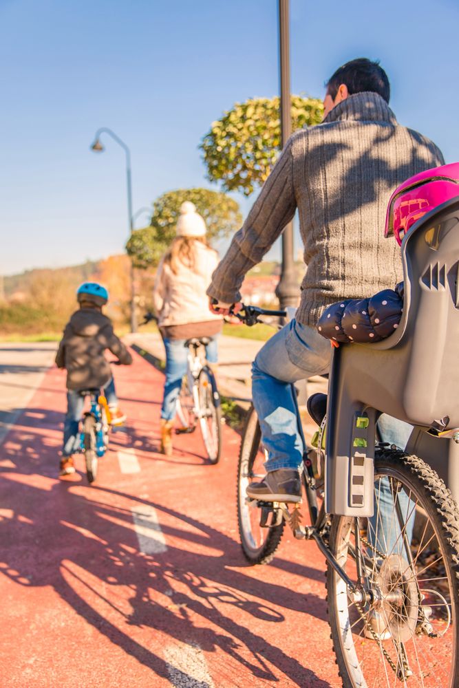 Back of family of 4 on bike ride together, vertical
