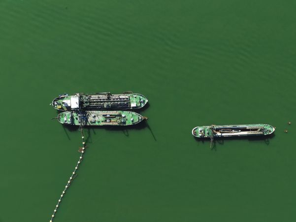 Plain teal green background of dredgers working.