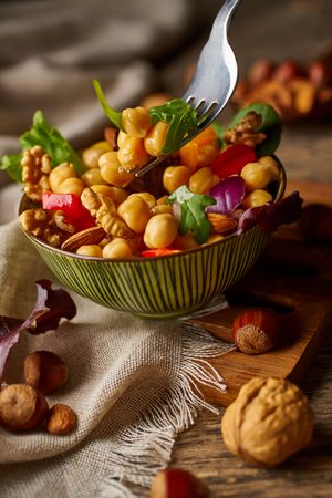 Bright vegetables with chickpeas in bowl and walnuts