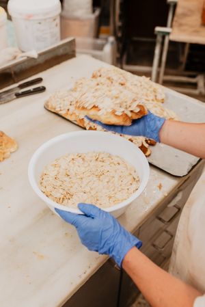 Crop baker making buns with almond flakes