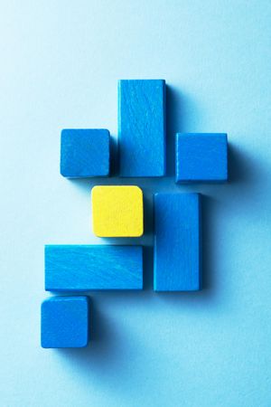 Blue and yellow wooden blocks over blue background