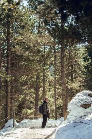 Man between winter forest in sunny day