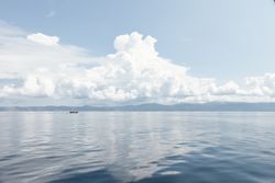 Big fluffy cloud over serene rippled sea