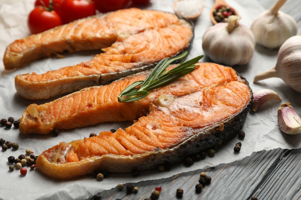 Composition with tasty grilled salmon on wooden background, close up