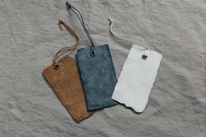 Set of colorful cotton paper tags mockups with metal rivets and strings for clothes