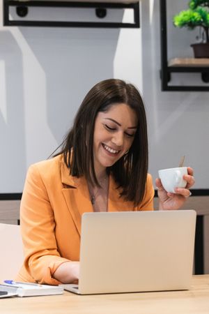 Optimistic woman working on laptop in cafe