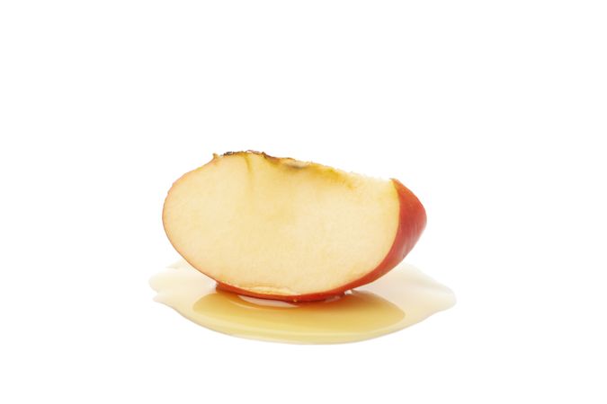 Apple slice sitting in honey
